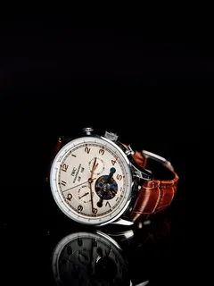 kulaté stříbrné chronograf hodinky s hnědým koženým řemínkem na zrcadle