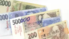 České bankovky různých hodnot rozložené na bílém pozadí