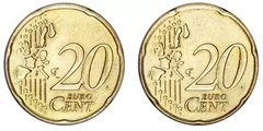 Dva dvacetieurocentové mince, pohled zepředu na žluté euromince vedle sebe.