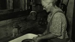 Černobílá fotografie ženy loupe brambory u dřezu, Pie Town 1940