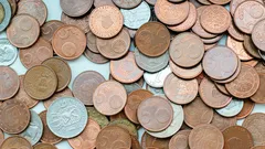 stříbrné a zlaté mince na bílém pozadí