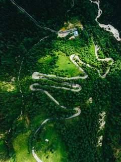 Letecký pohled na zelené stromy a silnici Vršič na jaře