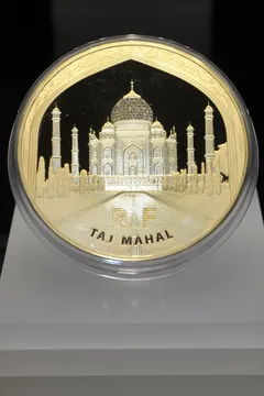 Zlatá mince s motivem Tádž Mahalu, indického architektonického skvostu na minci.